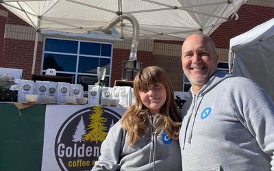 Ryan Wanner and his daughter at their farmers market stand